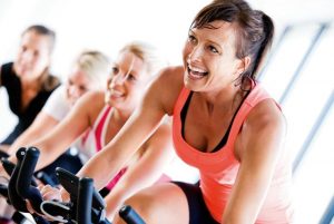 donne sorridenti che praticano spinning