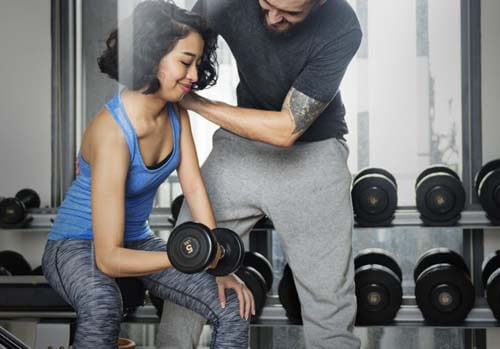 Istruttore segue ragazza in palestra