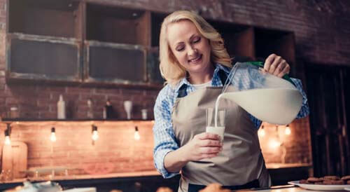 Lattaia versa latte in un bicchiere