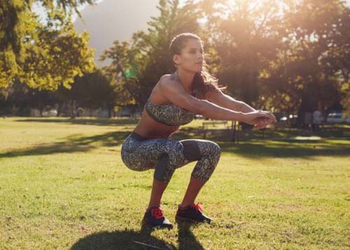 Ragazza fa squat all'aperto