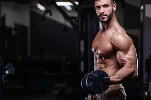 Uomo allena braccia in palestra