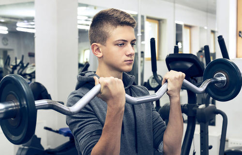 Adolescente che fa sollevamento pesi