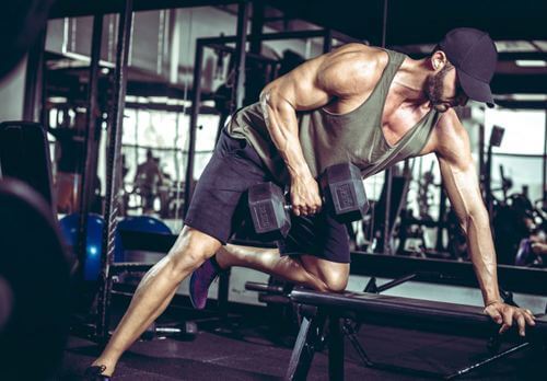 Uomo fa sollevamento pesi in palestra