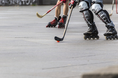 Ragazzi giocano a hockey con i rollerblade