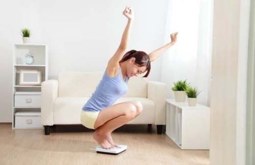 Donna che esulta sulla bilancia.