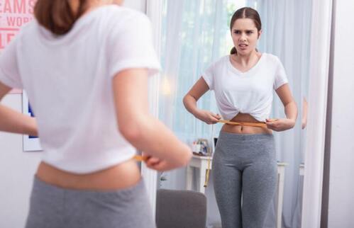 Donna che misura la circonferenza della pancia.