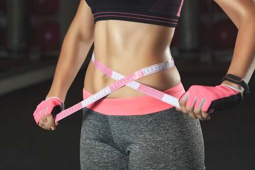 Donna con il ventre piatto.