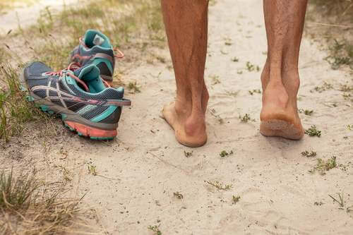 Uomo a piedi nudi sulla sabbia.