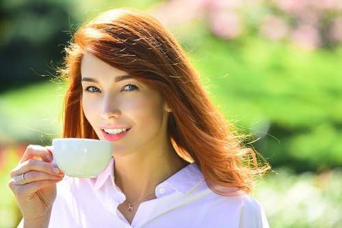 Donna che beve una tazza di caffè.