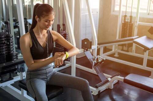 Donna in palestra che guarda l'orologio.