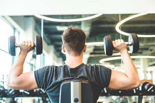 Ragazzo che allena le braccia in palestra.