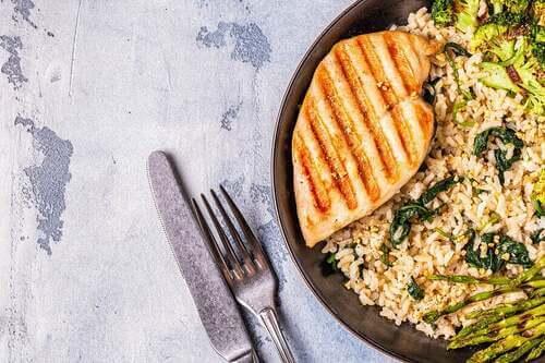 Pollo alla griglia con riso integrale e asparagi.