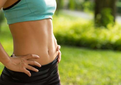 Donna sfoggia una pancia piatta.