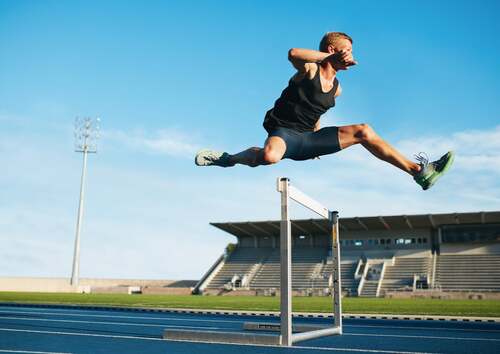 Atleta che salta un ostacolo.