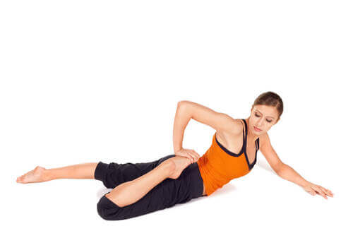 Donna che esegue lo stretching al quadricipite.