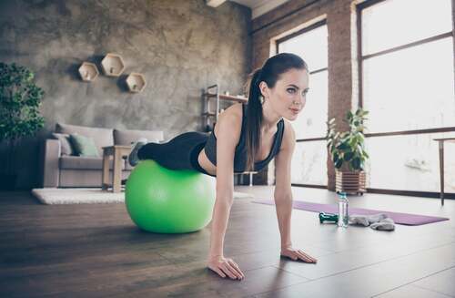 Donna che fa il plank con la fitball.
