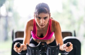 Ragazza che si allena sulla cyclette.